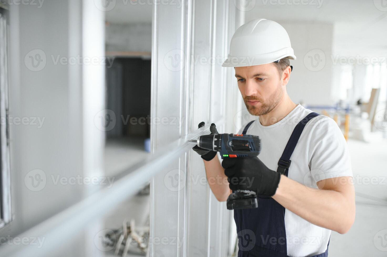 hombre sujetar metal perfil marco a el pared para panel de yeso mamparo foto