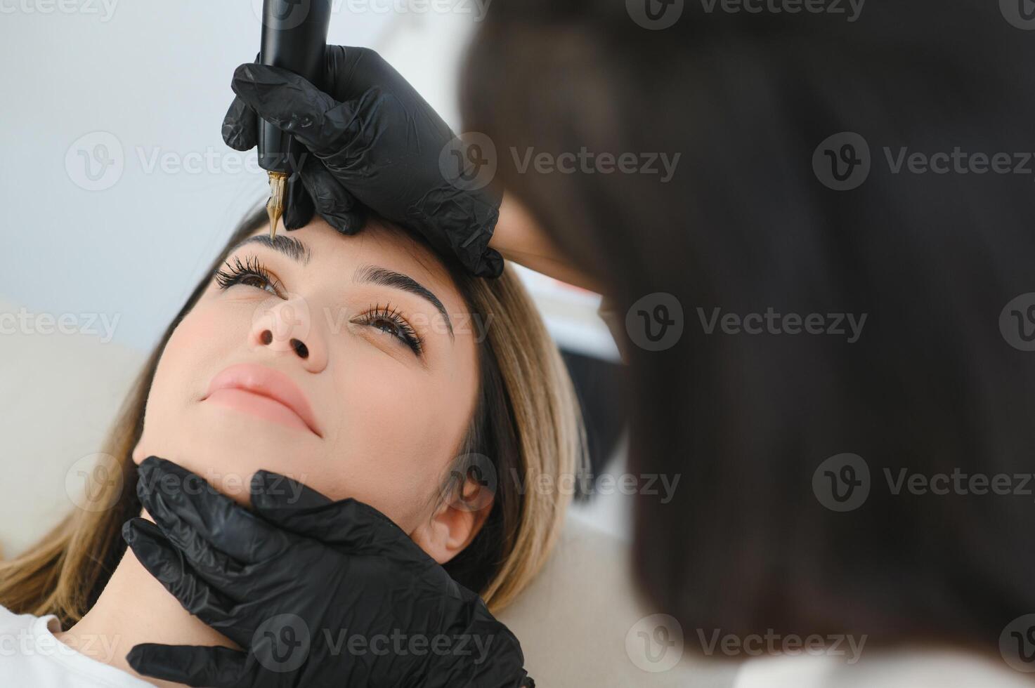 cosmetóloga aplicando permanente hacer arriba en Cejas- ceja tatuaje foto