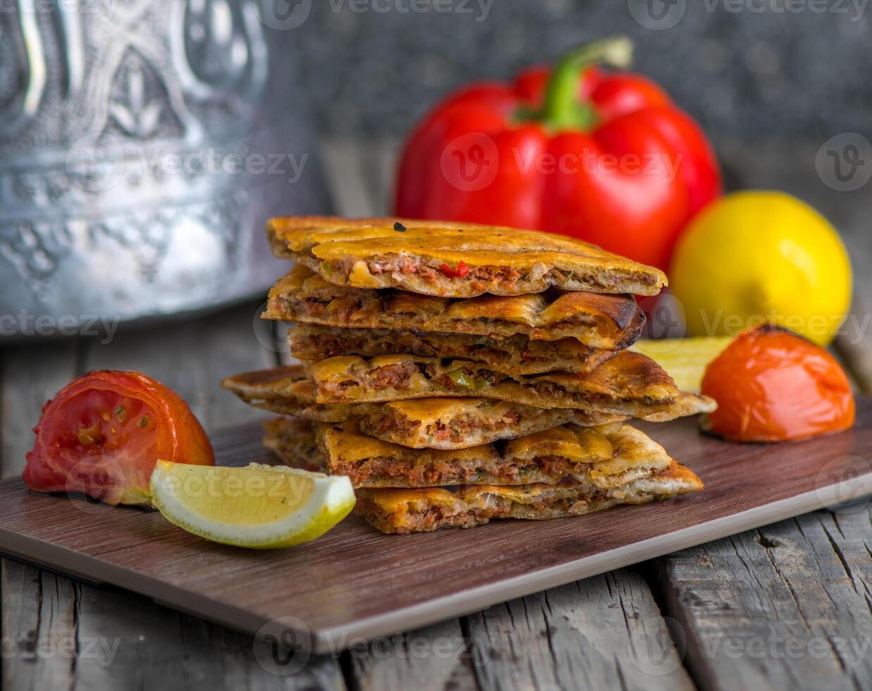 Spicy arrayes served in wooden board side view on wooden table background photo