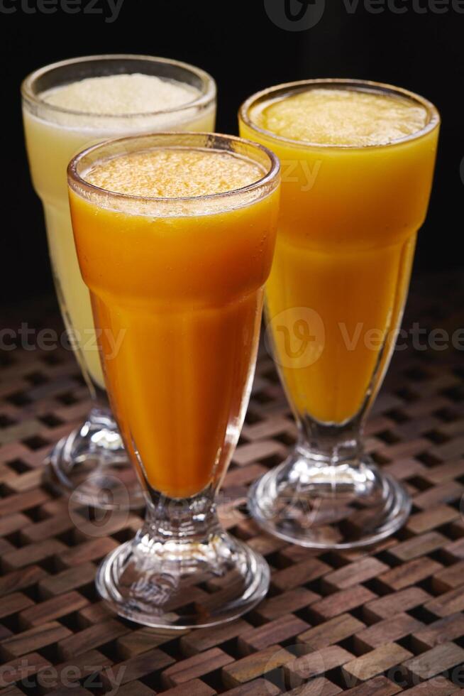 Assortment slush of Orange Mango Pineapple cocktail soda Drink served in glass isolated on table side view of middle east food photo