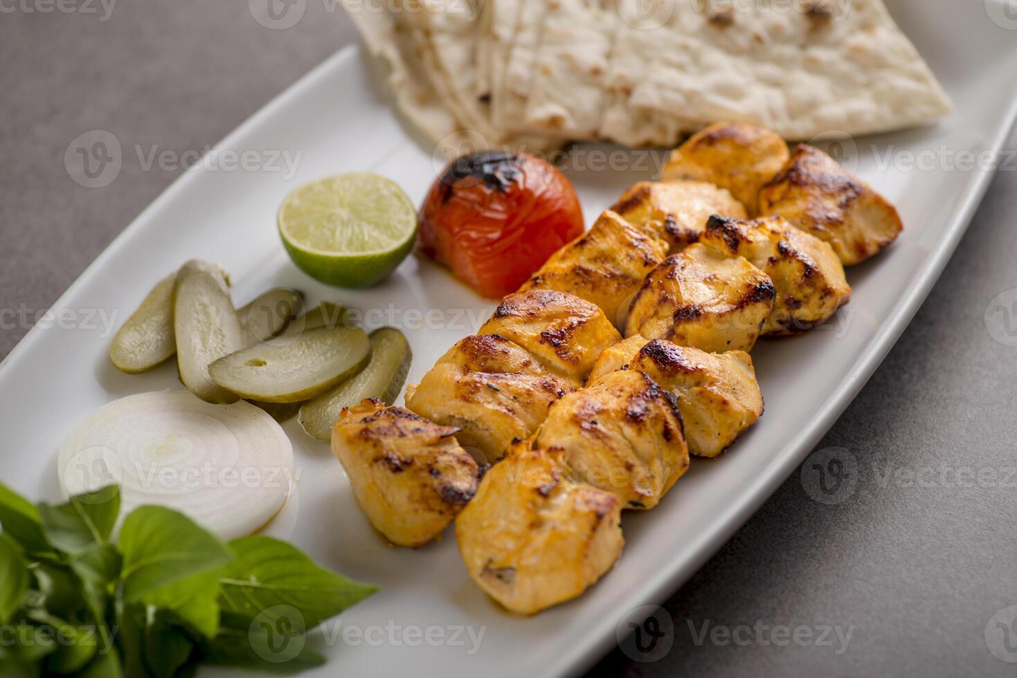 Jujeh chhicken tikka boti kabab with bread and salad served in dish isolated on grey background top view of arabic food photo