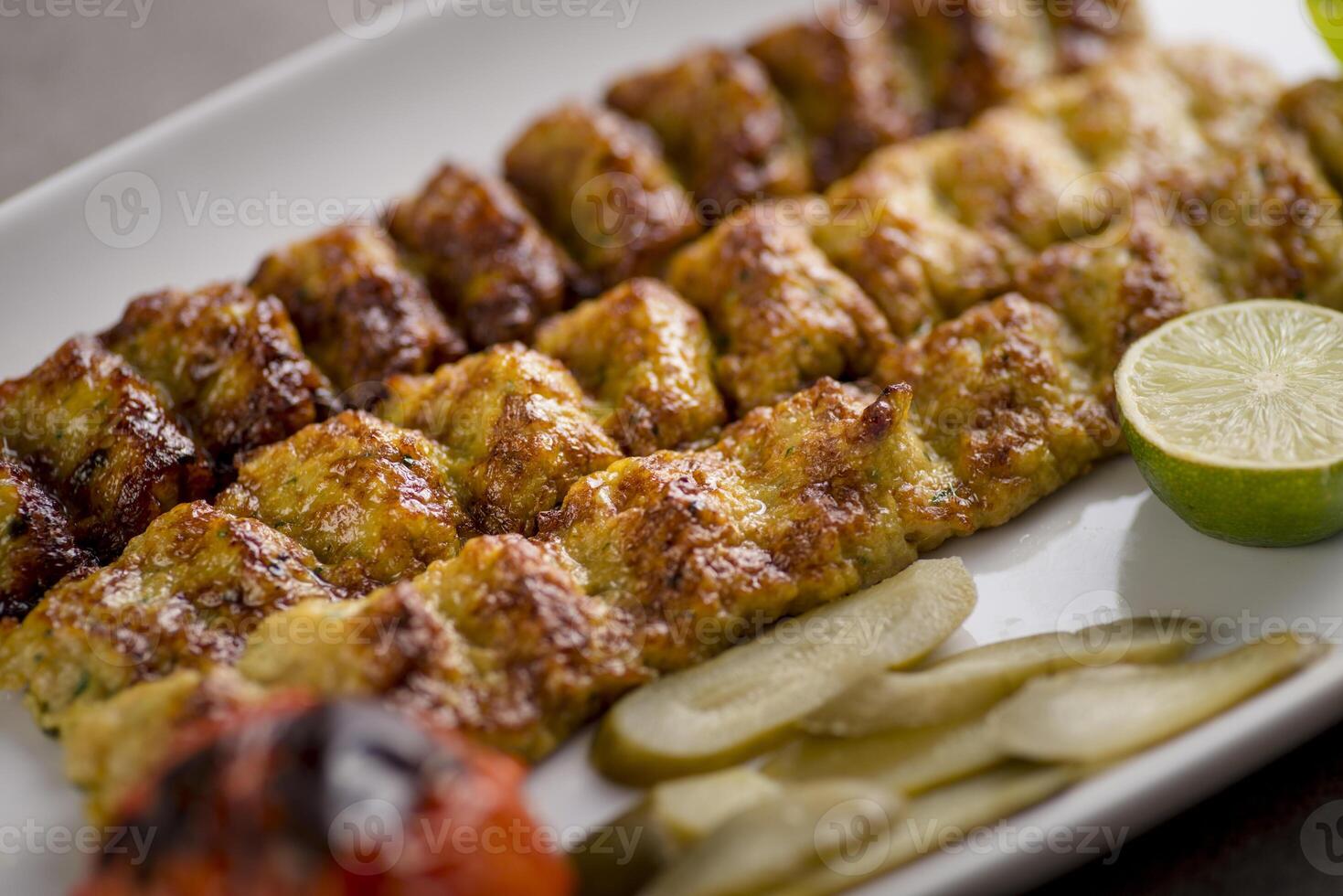 jujeh kebab kofta with lime served in dish isolated on grey background top view of arabic food photo