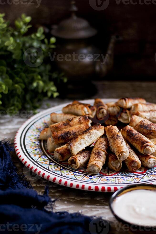 Assorted mosakhan fried roll served in a dish isolated n wooden table side view photo