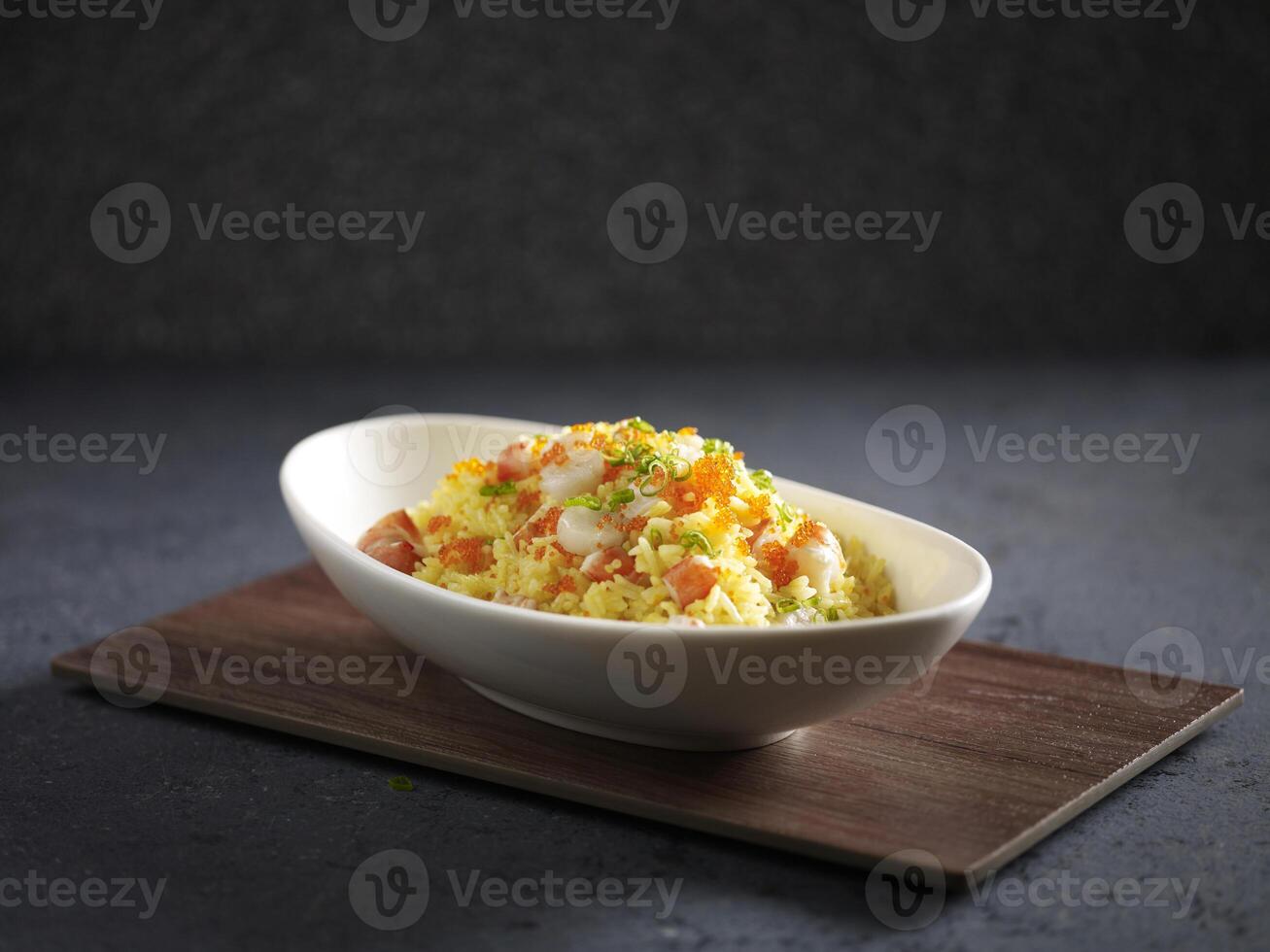 Supreme Seafood Fried Rice served in a dish isolated on cutting board side view on dark background photo