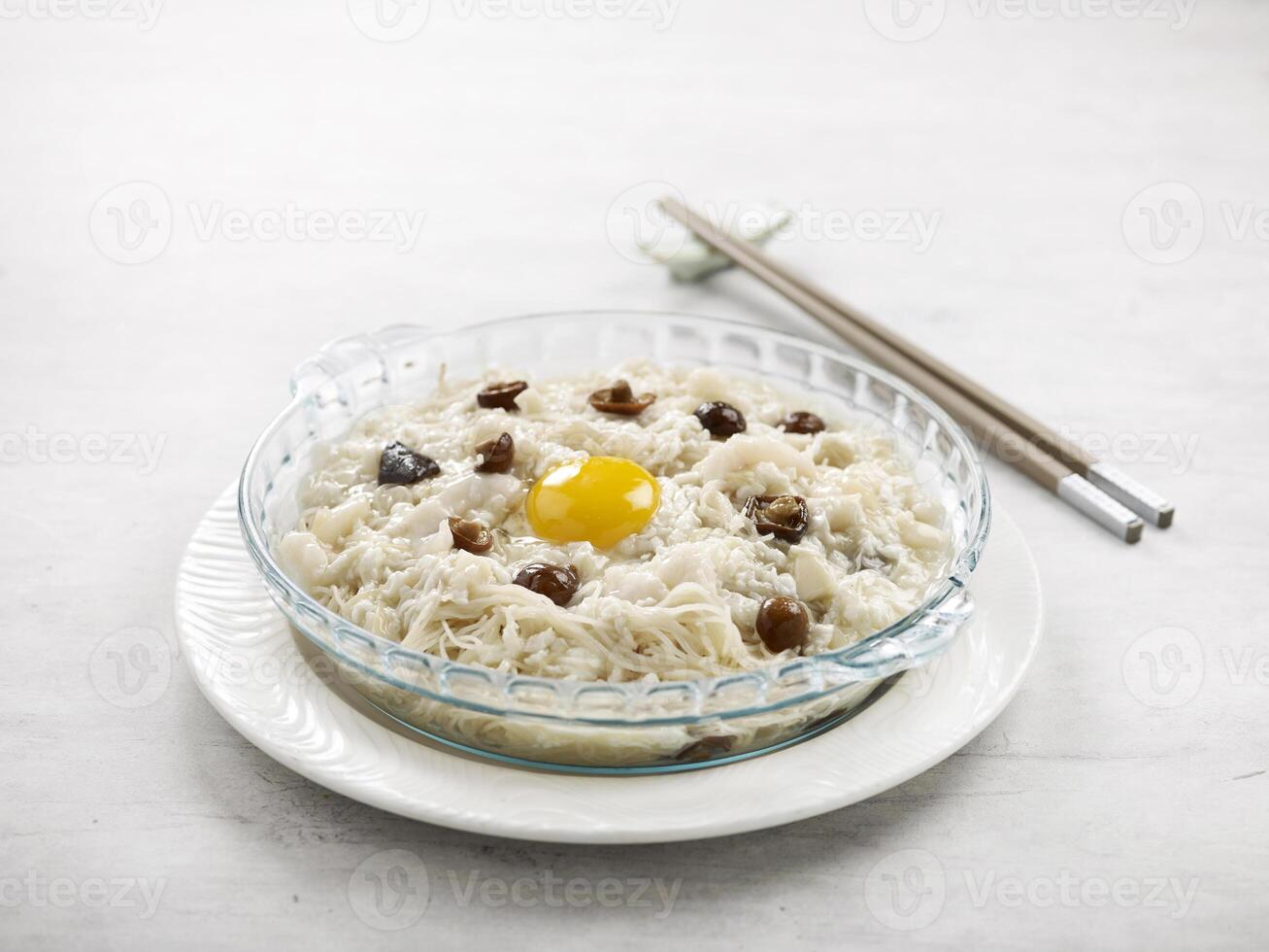 Stewed Vermicelli topped with Shredded Fish and Conpoy served in a dish side view on grey background photo