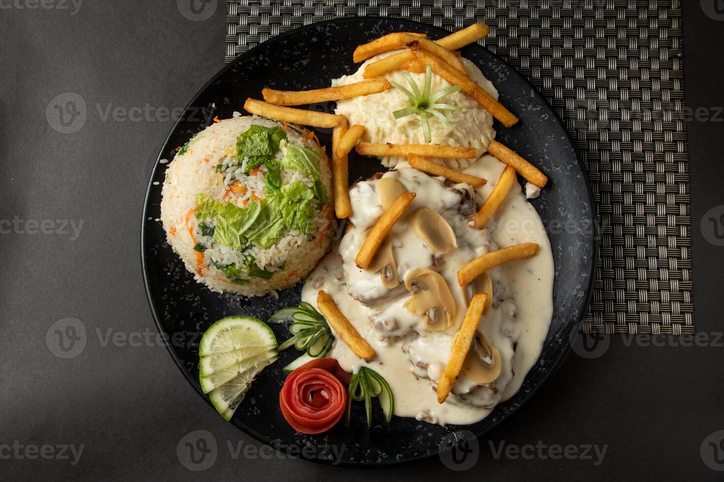 mushroom chicken piccata, fried rice, fries and salad served in dish isolated on background top view of bangladesh and indian food photo