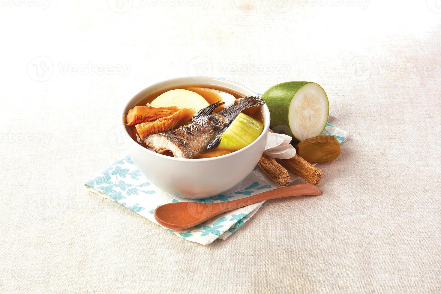 Codonopsis, Huaizaojie, Gourd and Mountain Spotted Fish Soup served in a bowl isolated on napkin side view of hong kong food photo