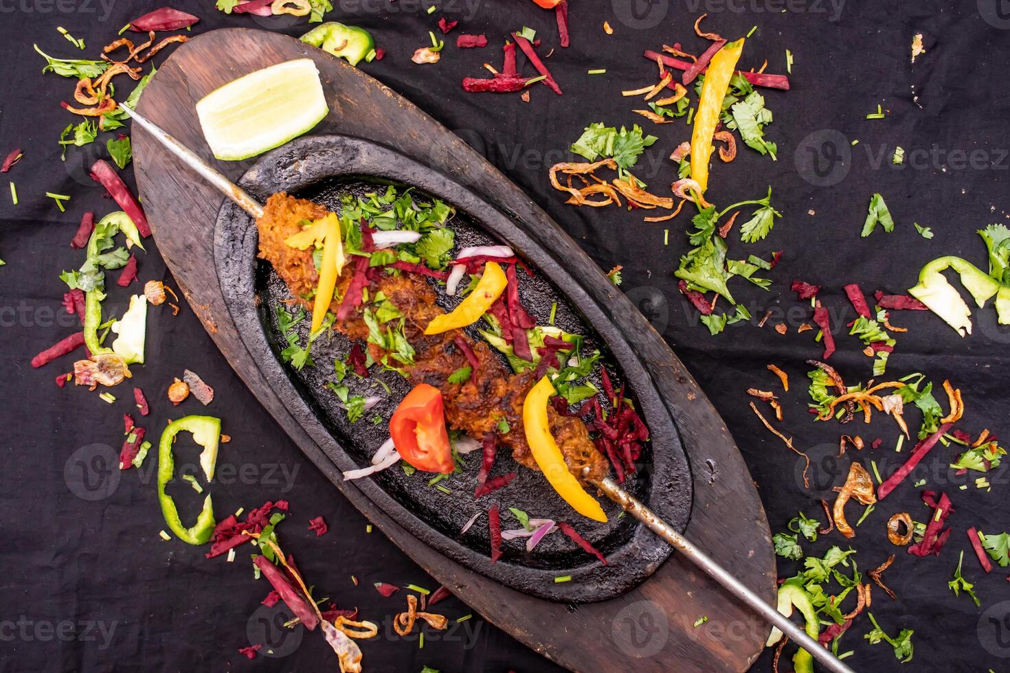 Beef seekh kabab with lemon served in dish isolated on dark background top view of indian spices food photo