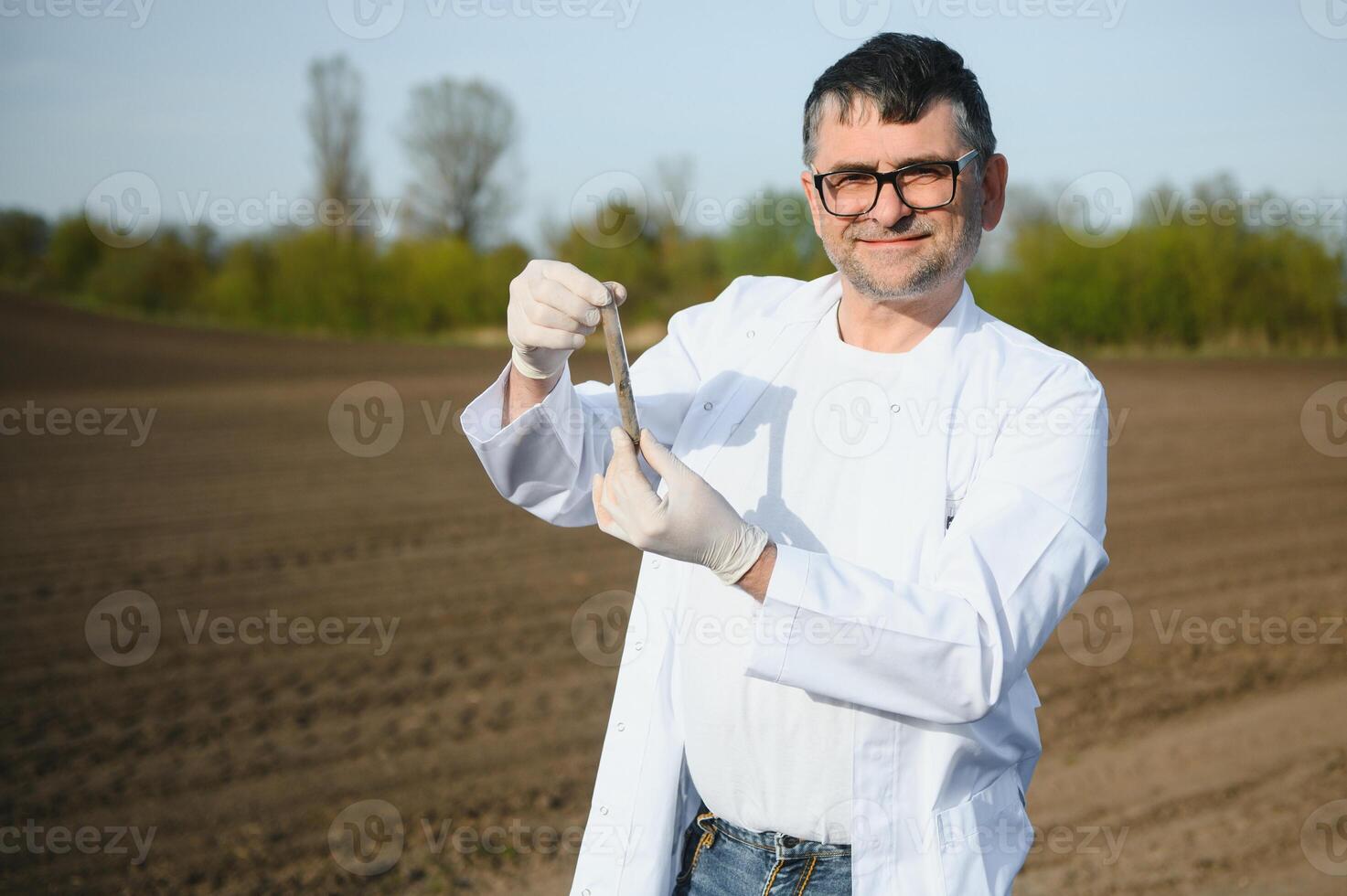 Soil Sampling. Agronomist taking sample with soil probe sampler. Environmental protection, organic soil certification, research photo