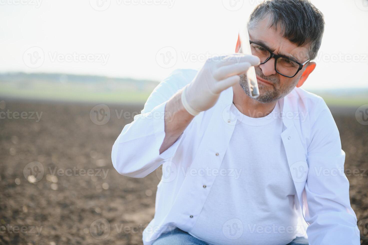 Soil Sampling. Agronomist taking sample with soil probe sampler. Environmental protection, organic soil certification, research photo