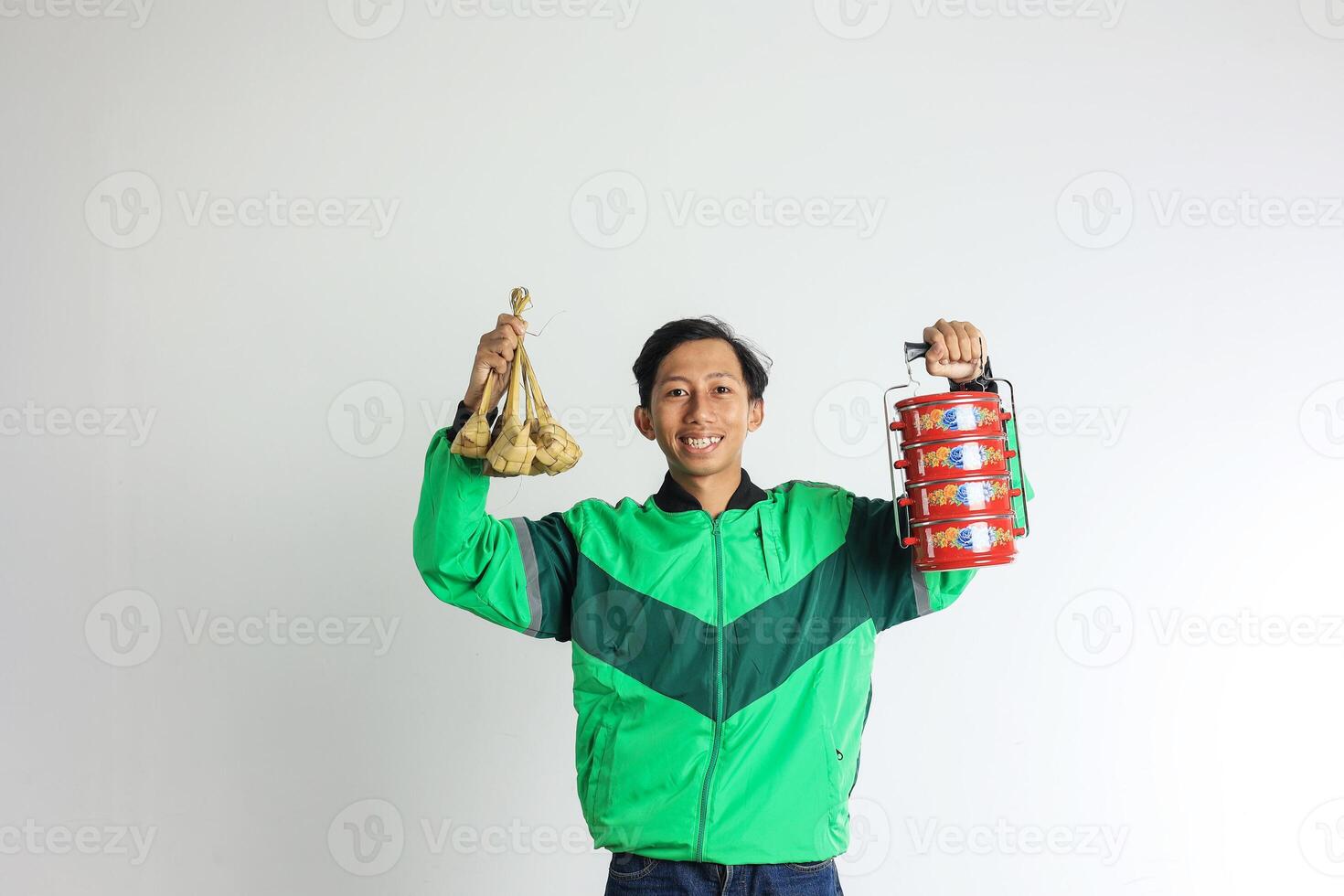 asiático masculino en línea conductor entregando ketupat y lado plato en rojo apilado caja de almuerzo foto