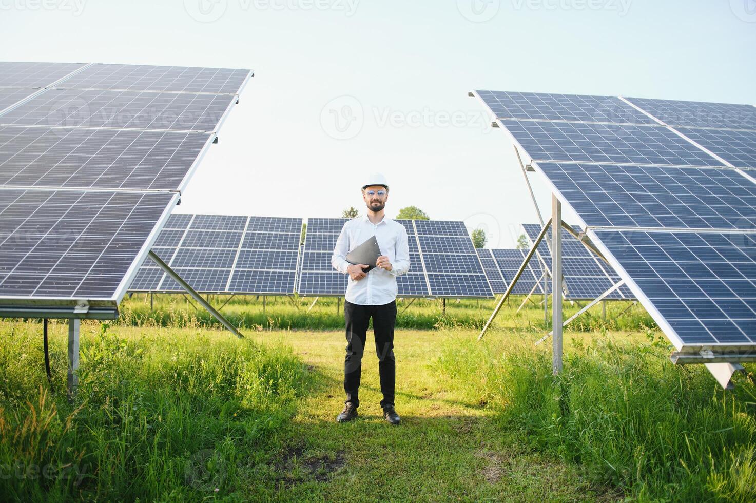 positivo barbado masculino inversor en pie en contra fotovoltaica paneles productor alternativa energía. foto