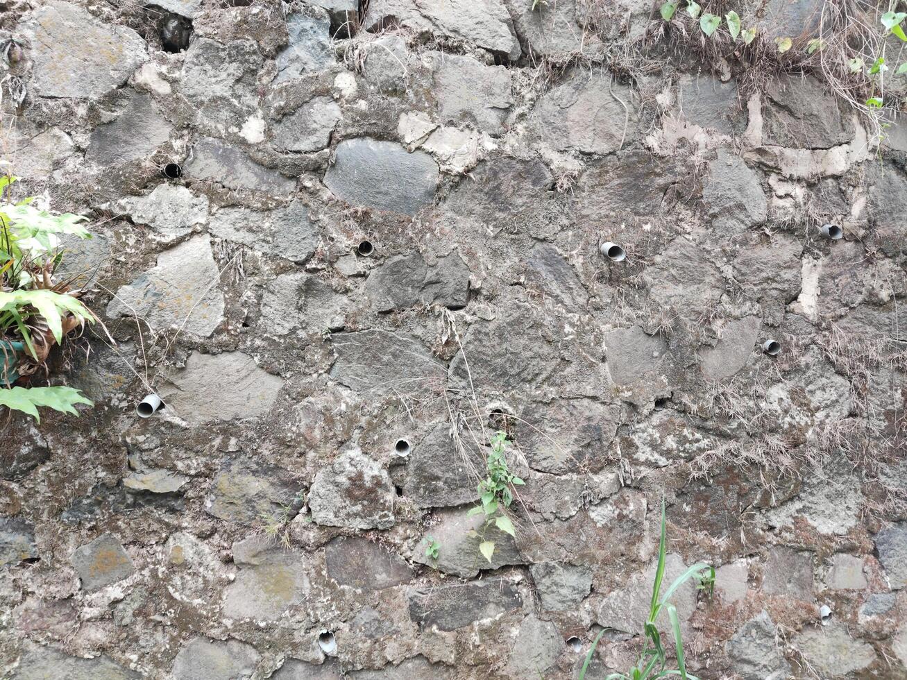 Stone wall as a cliff and road barrier photo