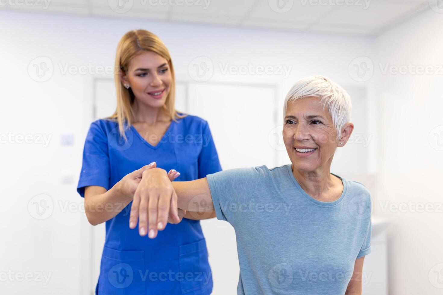 Doctor or Physiotherapist working examining treating injured arm of senior patient, stretching and exercise, Doing the Rehabilitation therapy pain in clinic. photo
