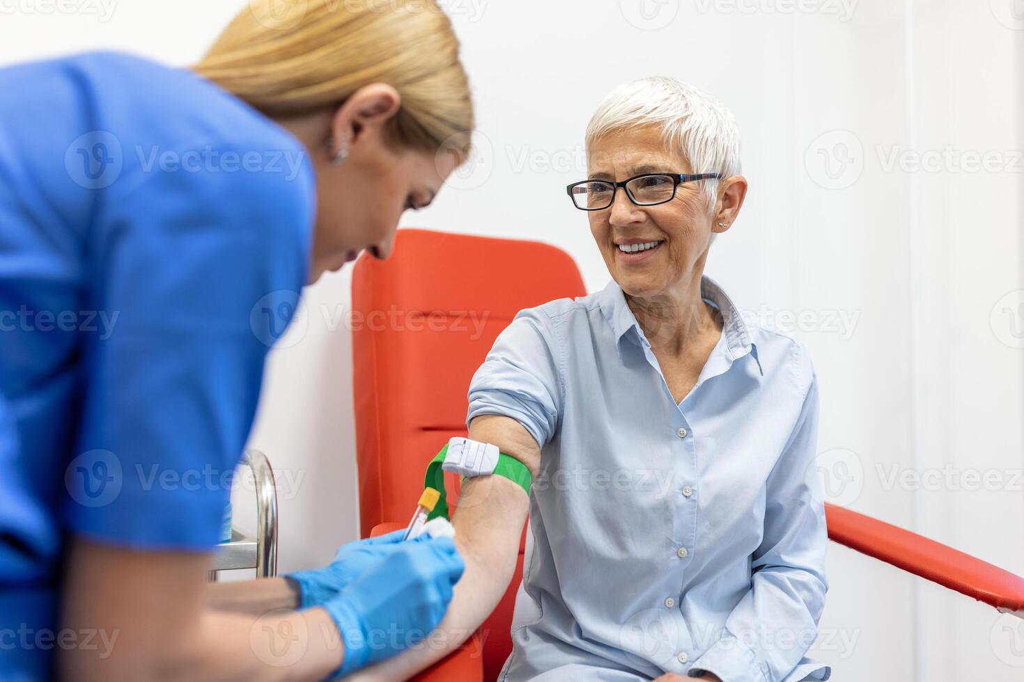 Medical technologist doing a blood draw services for patient. lab assistant with sterile rubber gloves taking blood sample from patient. photo