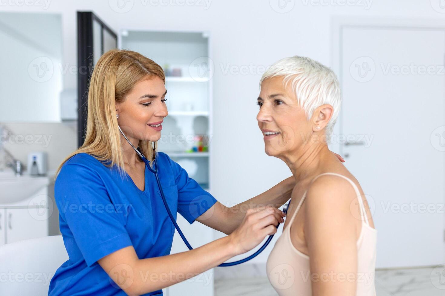 Caring female doctor use phonendoscope examine senior patient heart rate at consultation in hospital. Woman nurse or GP use stethoscope listen to woman's heartbeat in clinic. photo