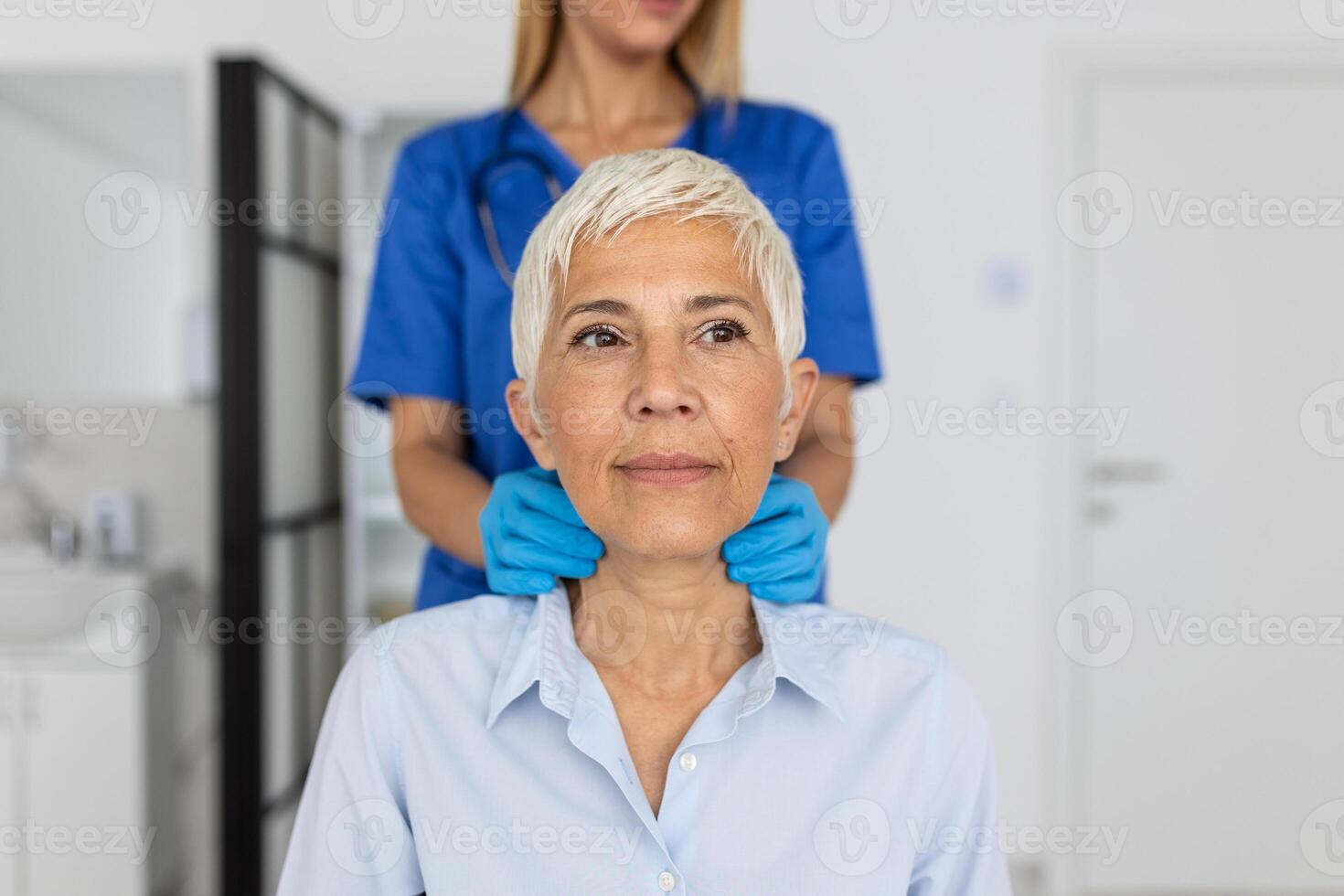 simpático mujer médico vistiendo guantes comprobación dolorido garganta o tiroides glándulas, conmovedor cuello de mayor hembra paciente visitando clínica oficina. tiroides cáncer prevención concepto foto