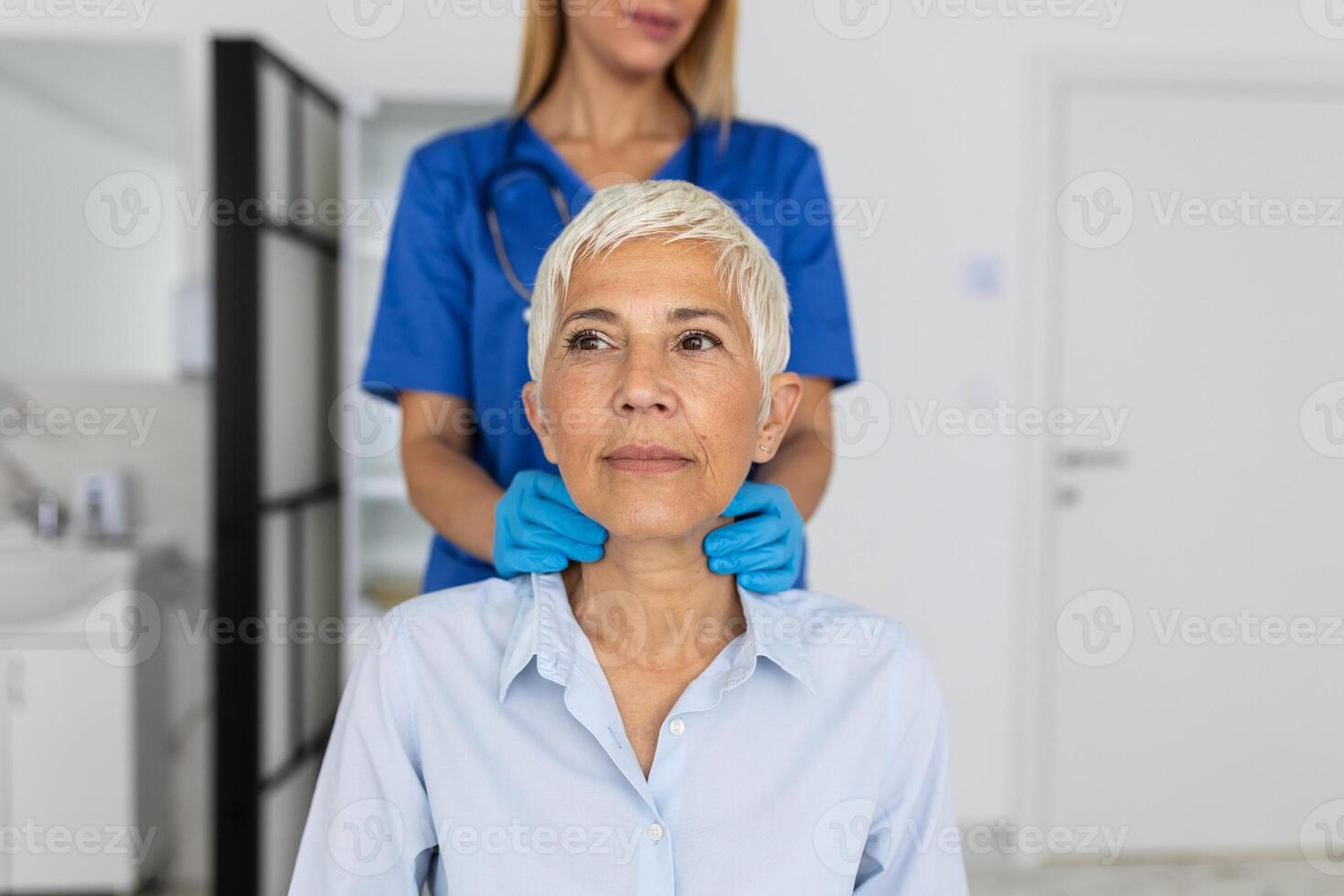 simpático mujer médico vistiendo guantes comprobación dolorido garganta o tiroides glándulas, conmovedor cuello de mayor hembra paciente visitando clínica oficina. tiroides cáncer prevención concepto foto