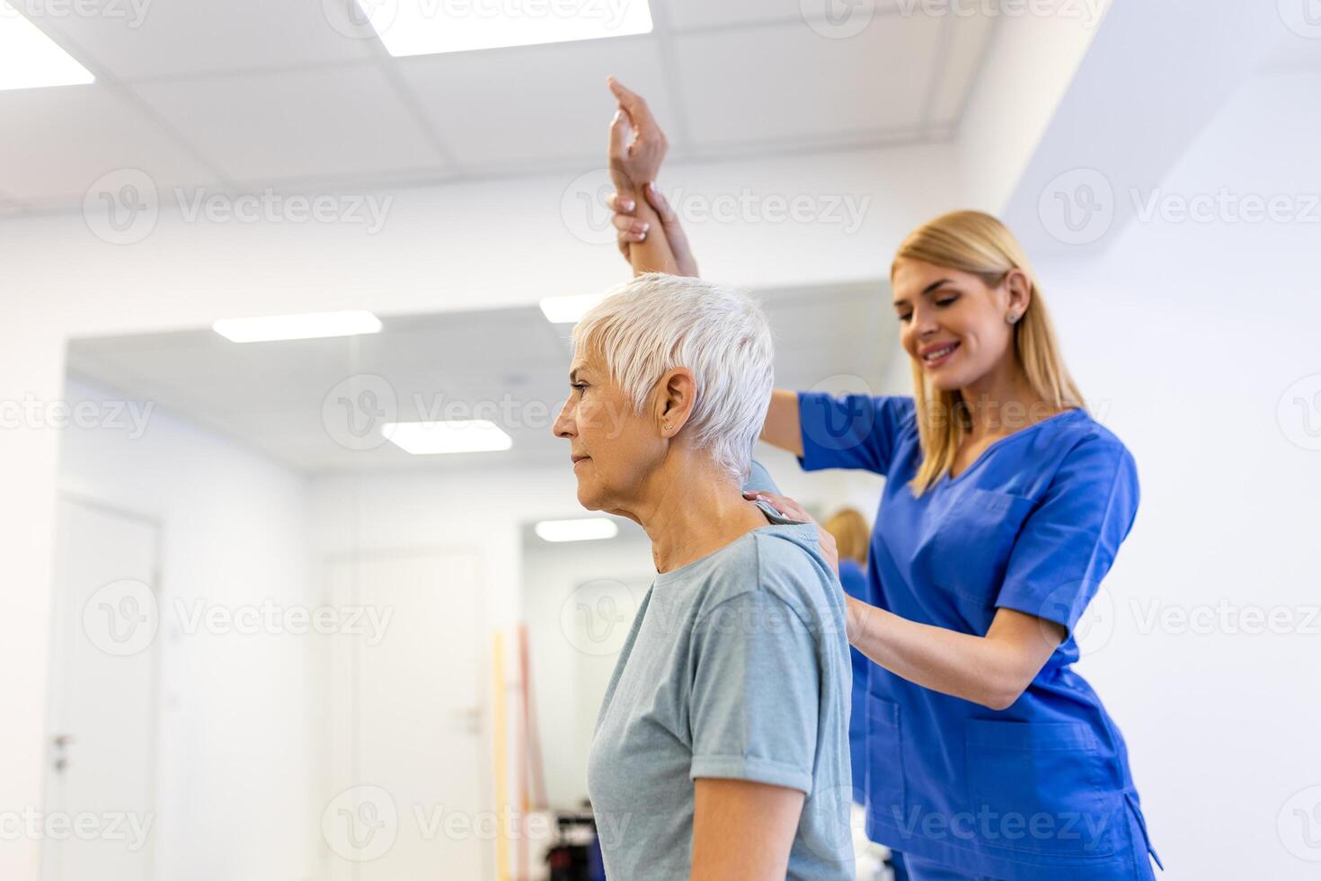 A Modern rehabilitation physiotherapy worker with senior client. Physiotherapist working with mature patient in rehabilitation center photo