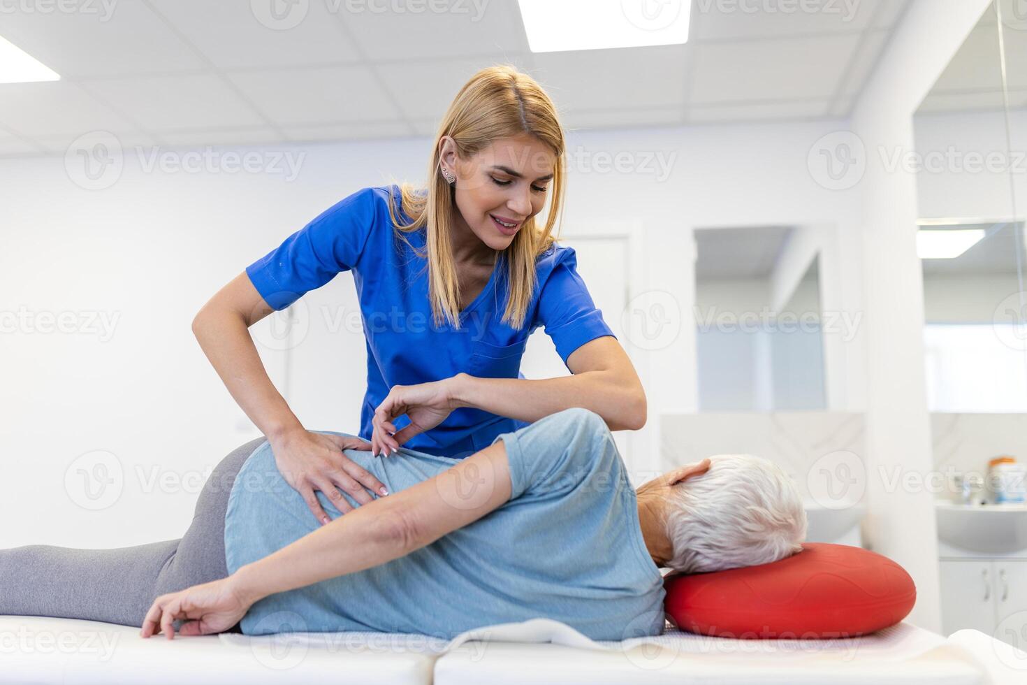 joven médico quiropráctico o osteópata fijación acostado mayor mujer espalda con manos movimientos durante visitar en manual terapia clínica. profesional quiropráctico durante trabajo foto