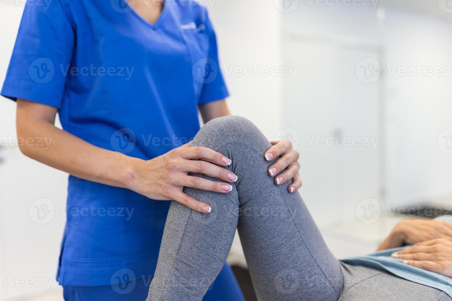 fisioterapeuta trabajando con paciente en clínica, de cerca. un moderno rehabilitación fisioterapia trabajador con mayor cliente, físico terapeuta extensión paciente rodilla foto