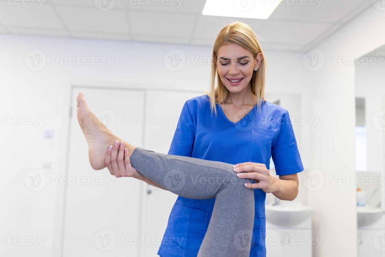 fisioterapeuta trabajando con paciente en clínica, de cerca. un moderno rehabilitación fisioterapia trabajador con mayor cliente, físico terapeuta extensión paciente rodilla foto