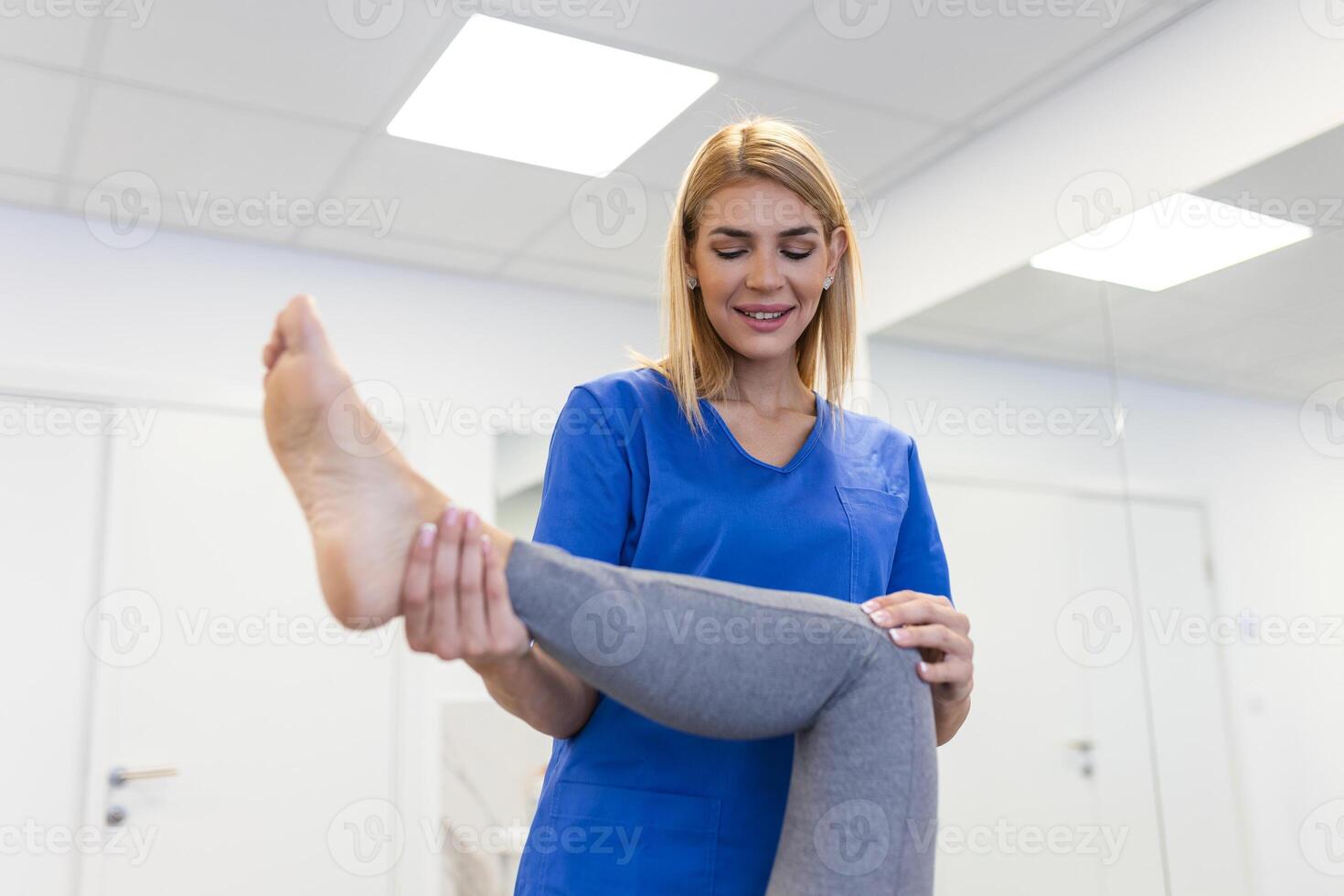 Physiotherapist working with patient in clinic, closeup. A Modern rehabilitation physiotherapy worker with senior client, Physical therapist stretching patient knee photo