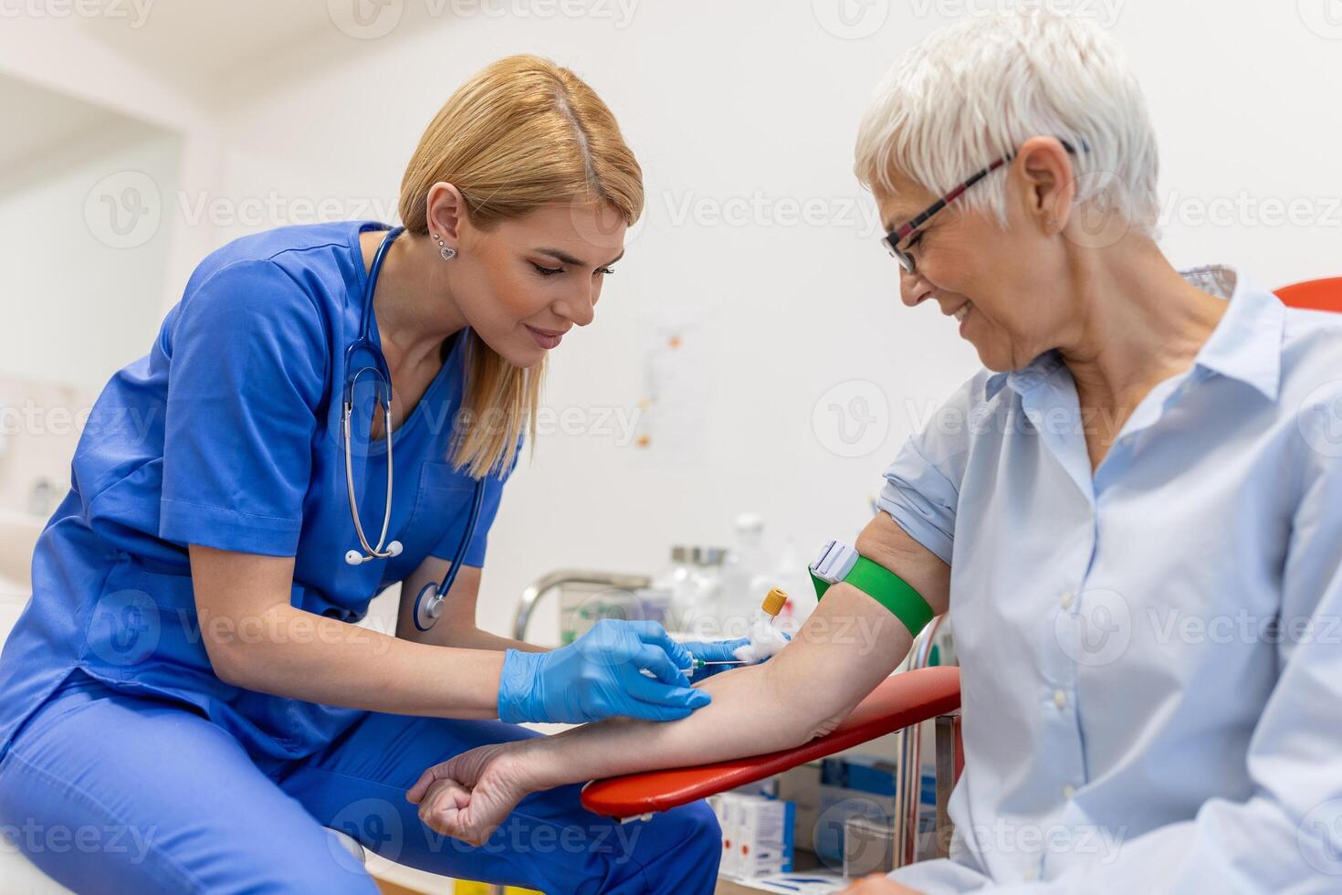 Medical technologist doing a blood draw services for patient. lab assistant with sterile rubber gloves taking blood sample from patient. photo