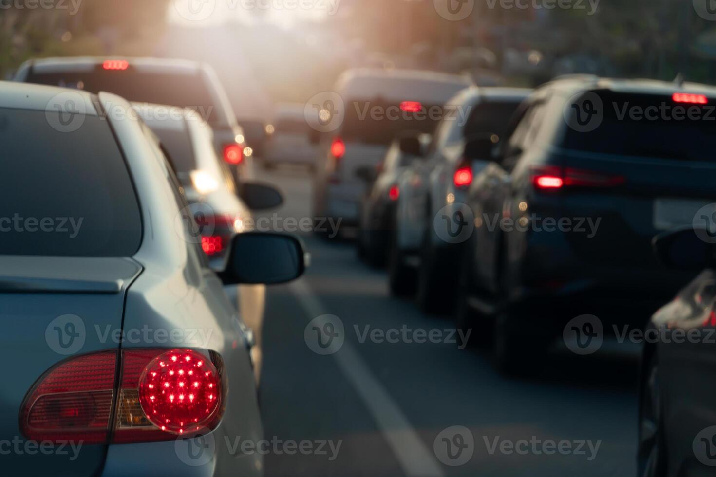 Rear side of grey car with turn on brake light.Traffic jam on the asphalt road with bokeh light background. photo