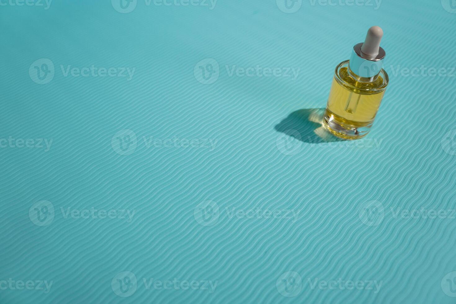 Face oil glass bottle on blue background photo