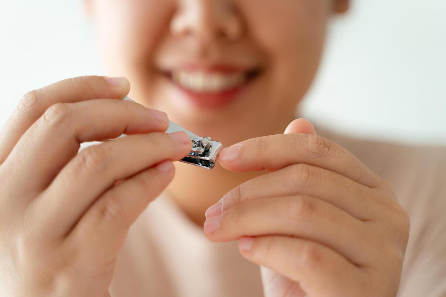 A woman is holding a pair of nail clippers and smiling photo