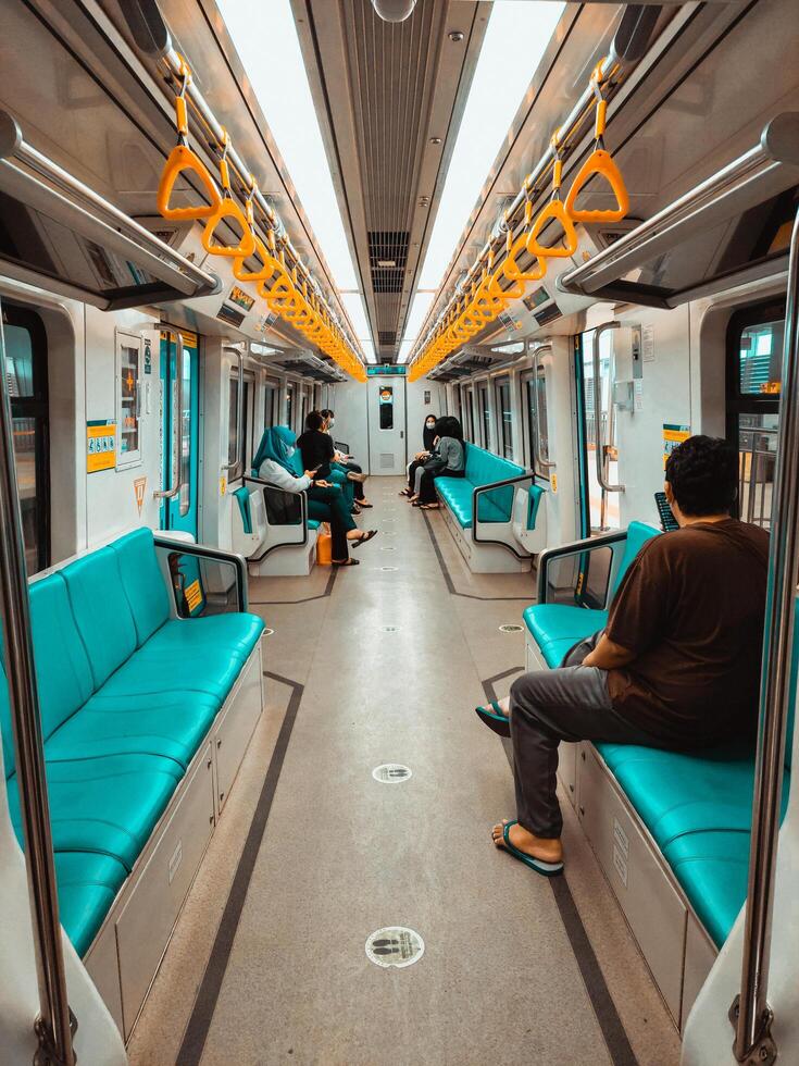 Palembang, Indonesia, June 16, 2022. Commuters on Mass Rapid Transit train. MRT is the latest public transportation system. MRT is a transportation for future. photo