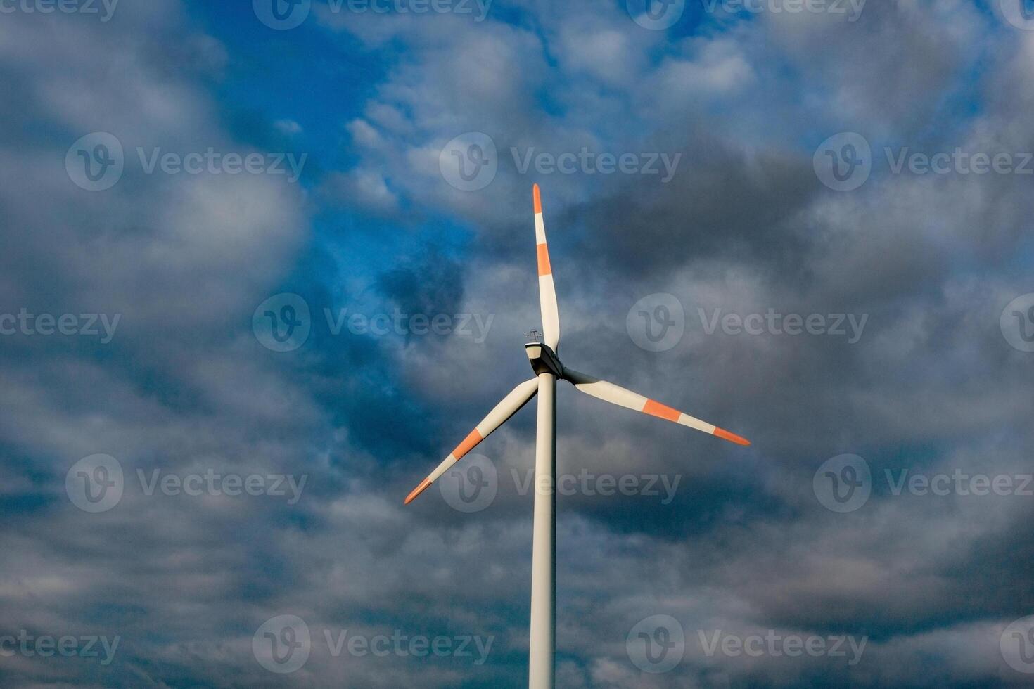 Wind turbine on the background of the blue sky. Clean renewable energy. Electric power production. photo