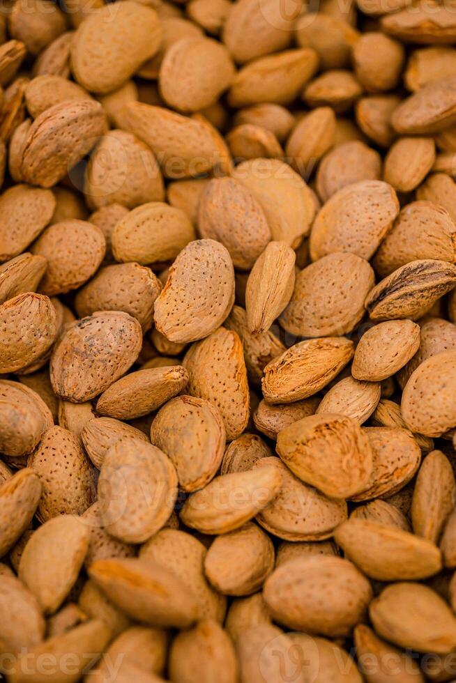 Almond nuts in a basket on a wooden background. photo