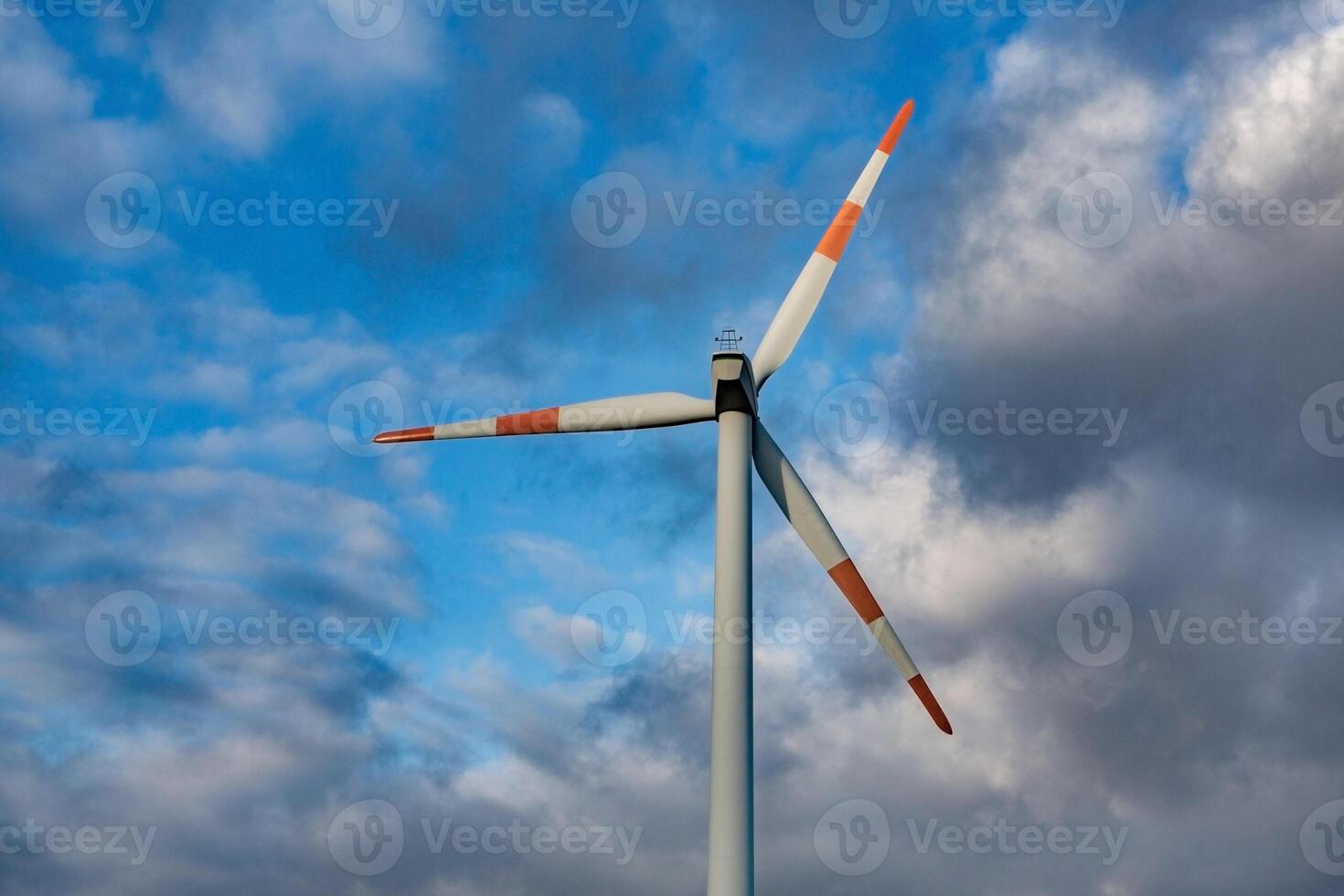Wind turbine on the background of the blue sky. Clean renewable energy. Electric power production. photo