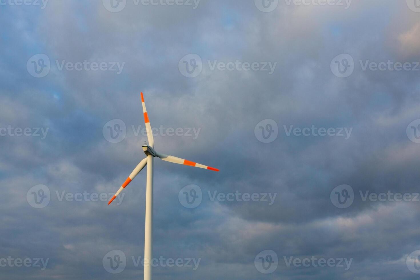 Wind turbine on the background of the blue sky. Clean renewable energy. Electric power production. photo