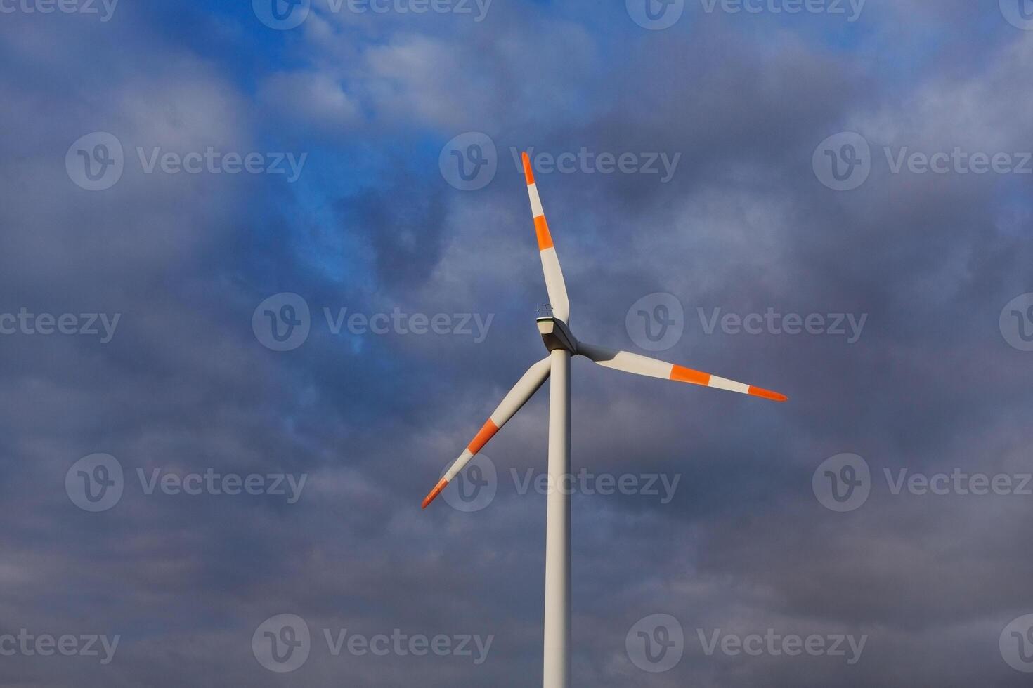 Wind turbine on the background of the blue sky. Clean renewable energy. Electric power production. photo