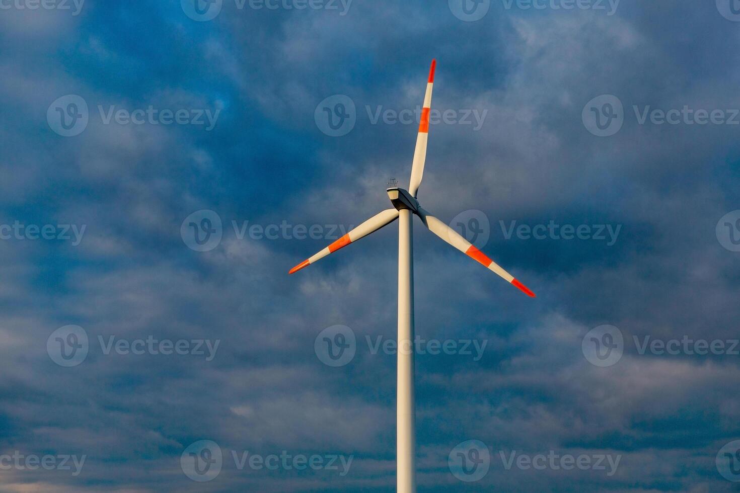 Wind turbine on the background of the blue sky. Clean renewable energy. Electric power production. photo
