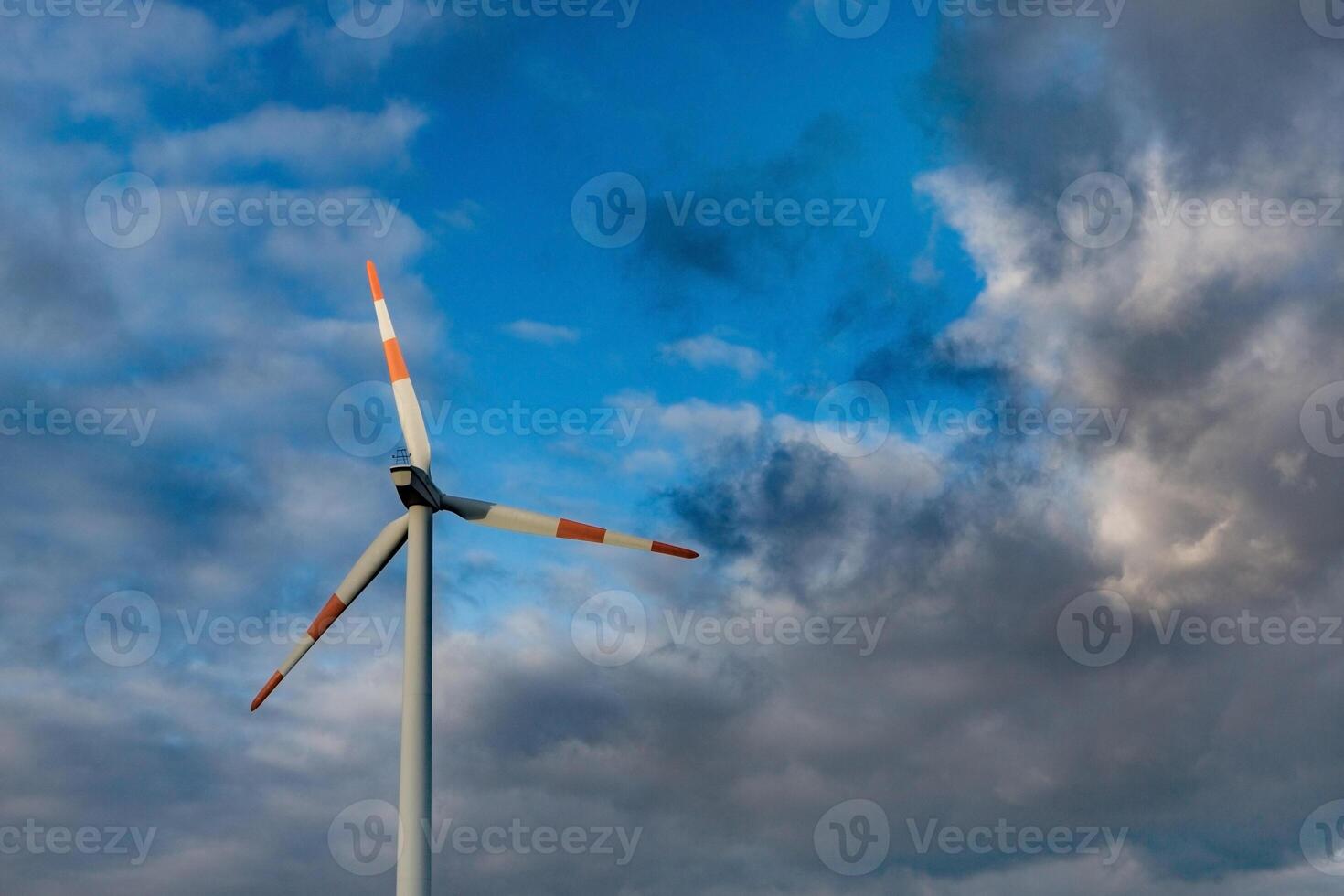 Wind turbine on the background of the blue sky. Clean renewable energy. Electric power production. photo