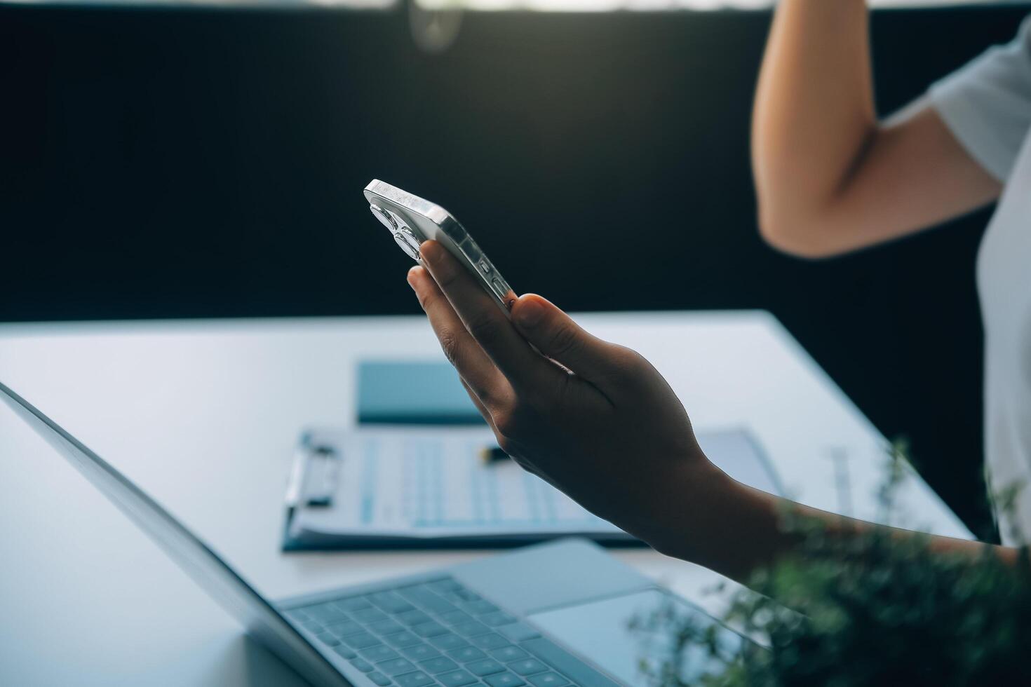 emocionada mujer asiática feliz mirando la pantalla del teléfono, celebrando una victoria en línea, joven asiática muy contenta gritando de alegría, aislada sobre un fondo blanco borroso foto