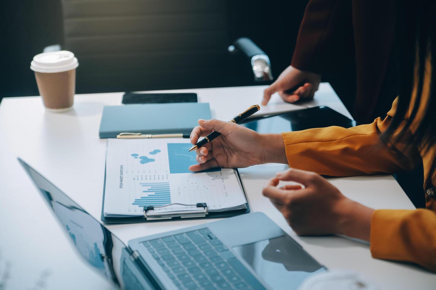 equipo de negocios financieros presente. las manos del hombre de negocios sostienen documentos con estadísticas financieras, fotos de stock, discusión y análisis de datos de informes de tablas y gráficos. finanzas concepto financiero