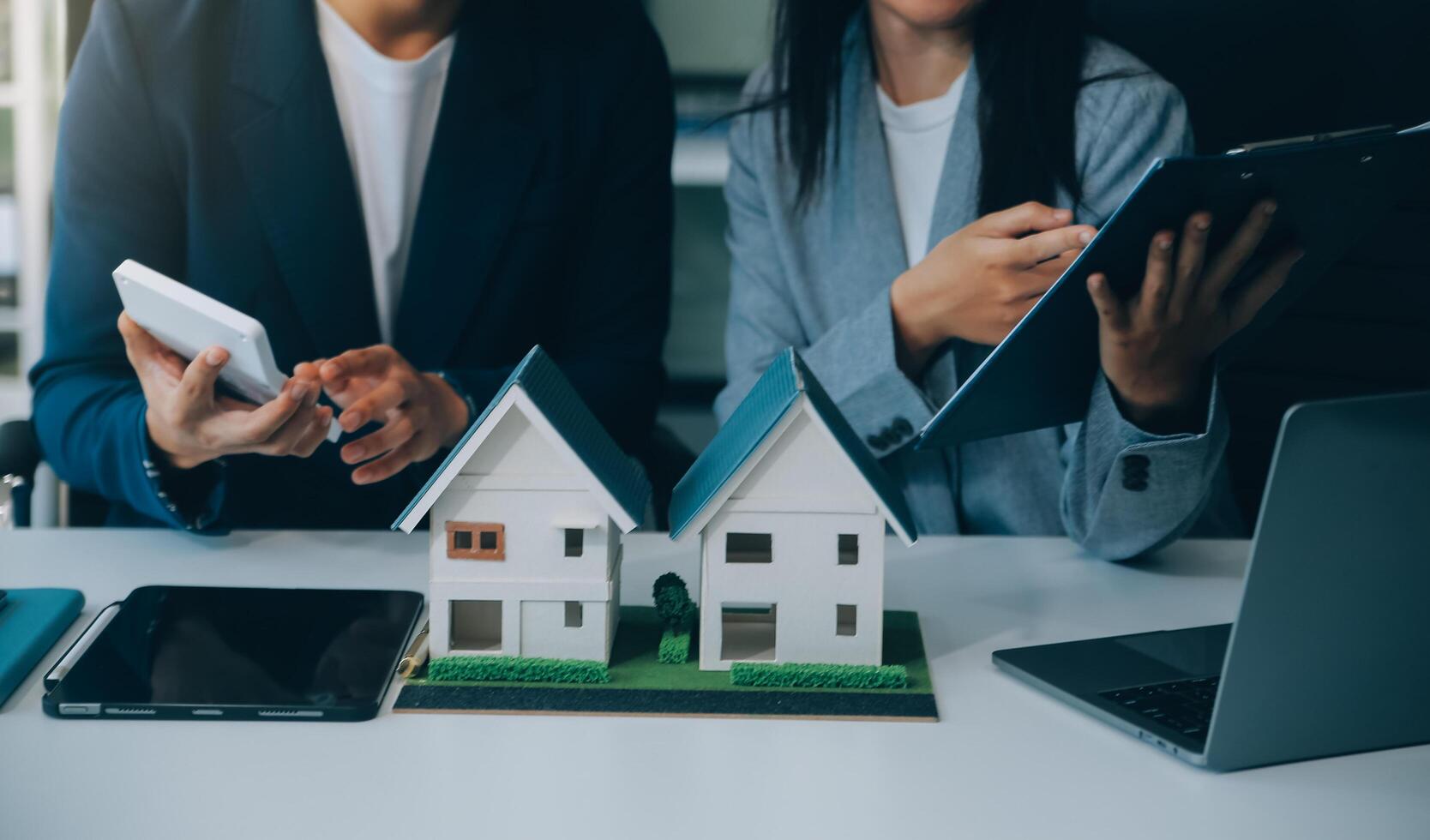 Real estate broker agent presenting and consult to customer to decision making sign insurance form agreement, buy and sell home model, concerning mortgage loan offer for and house insurance photo