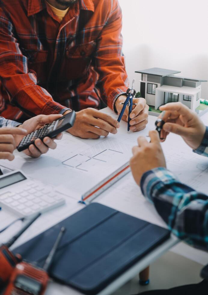 engineer people meeting working and pointing at a drawings in office for discussing. Engineering tools and construction concept. photo