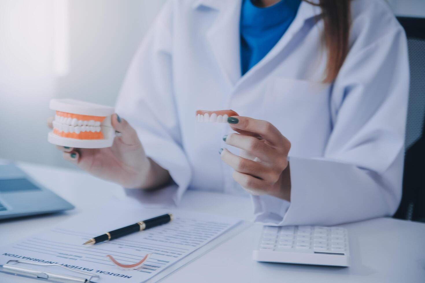 los dentistas están discutiendo problemas dentales al informar la imagen de rayos X en la pantalla del portátil a los pacientes. foto