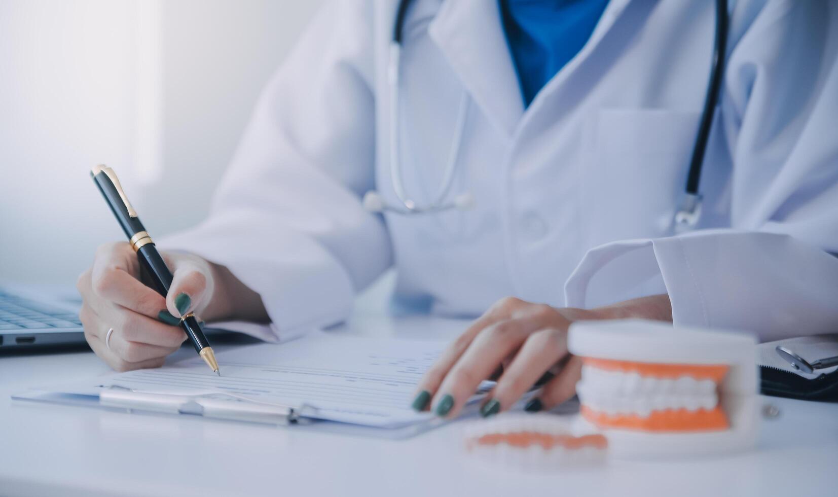 los dentistas están discutiendo problemas dentales al informar la imagen de rayos X en la pantalla del portátil a los pacientes. foto