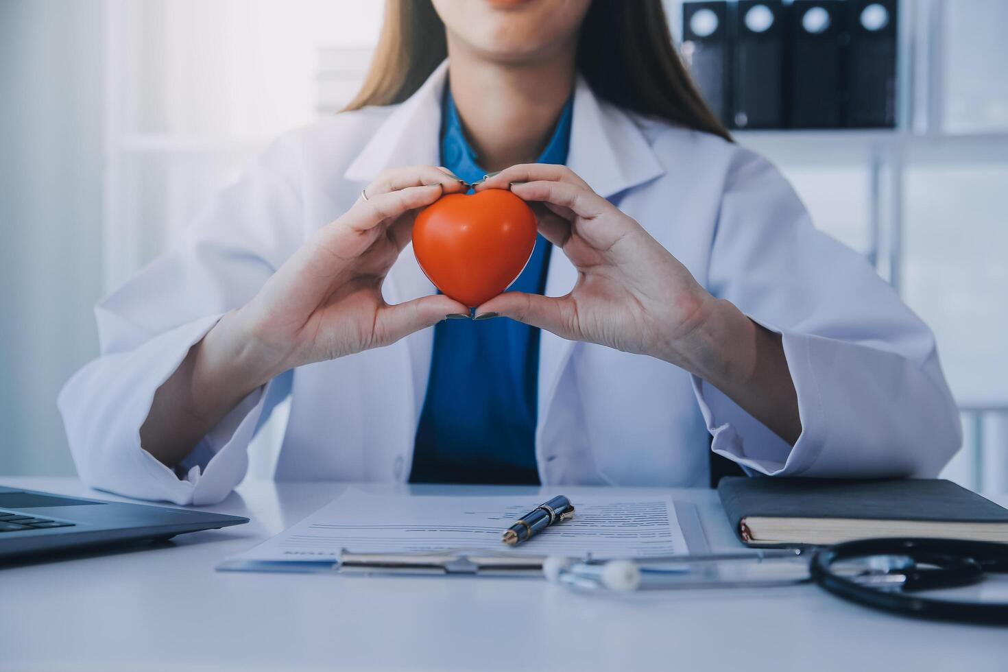 médico explicando corazón a mayor paciente. médico explicando el corazón modelo. doctores bolígrafo punto a un modelo de el corazón foto