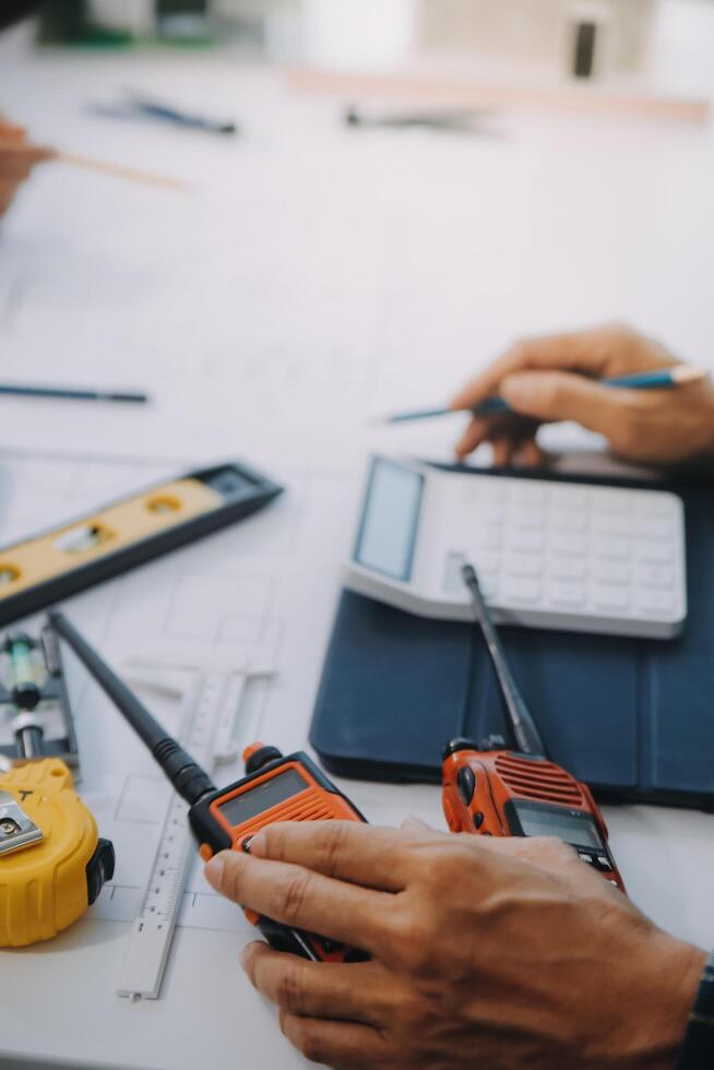 engineer people meeting working and pointing at a drawings in office for discussing. Engineering tools and construction concept. photo