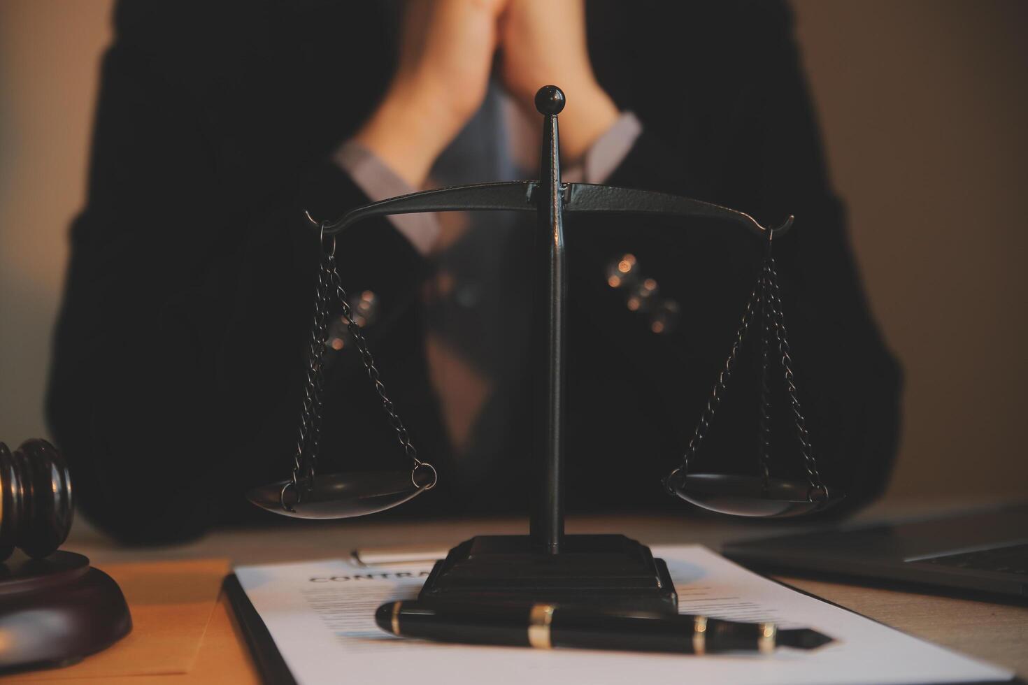 Business and lawyers discussing contract papers with brass scale on desk in office. Law, legal services, advice, justice and law concept picture with film grain effect photo