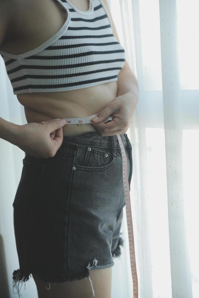 Women body fat belly. Obese woman hand holding excessive belly fat. diet lifestyle concept to reduce belly and shape up healthy stomach muscle. photo