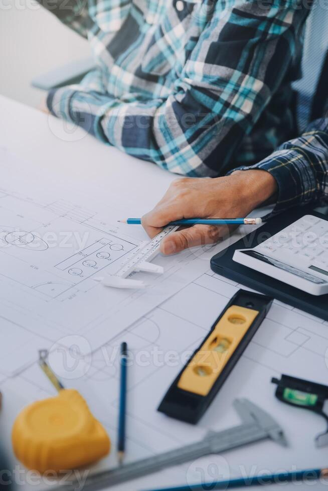 engineer people meeting working and pointing at a drawings in office for discussing. Engineering tools and construction concept. photo